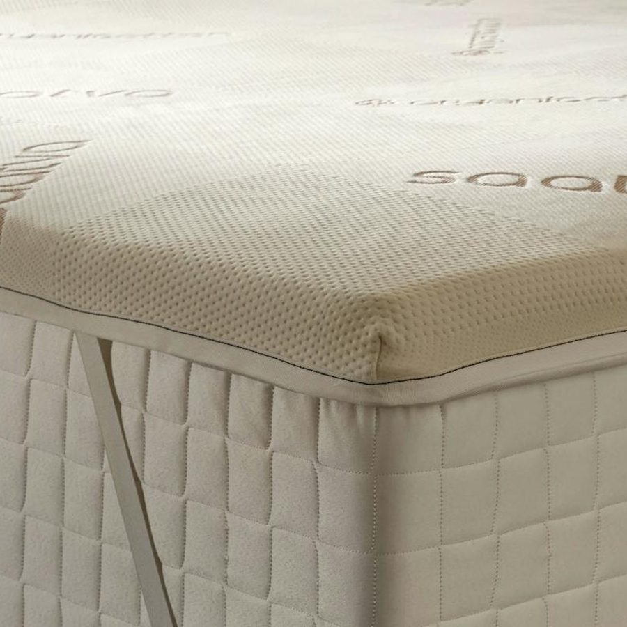 Corner of the Saatva High-Density Foam Mattress Topper with its anchor strap